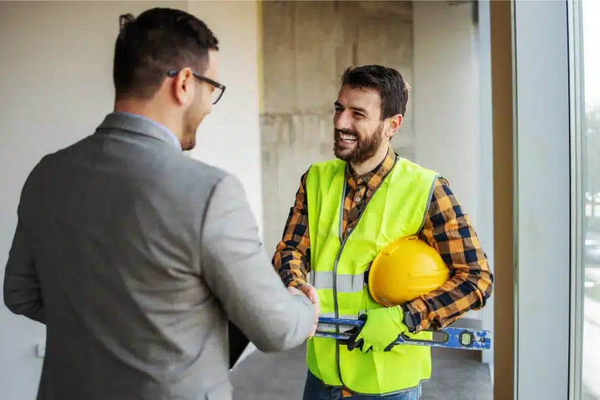 construction worker shaking hands with a guy in a suit